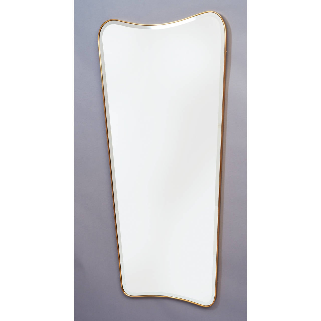 Long free-form shaped mirror with bevel and brass frame, in the style
of Gio Ponti,

Italy, 1950s.

Measure: 58 H x 27 W.