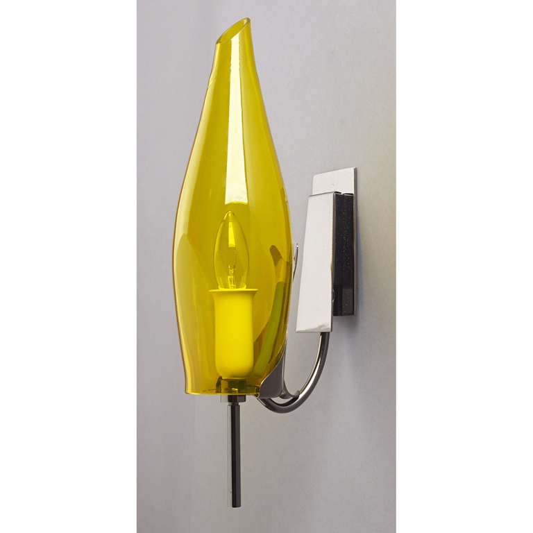 Italy, 1970's
Pair of yellow blown glass sconces with black nickeled metal mounts.
Rewired for use in the U.S.A.  with one candelabra base bulb
Measures  5 W x 6 D x 14 H.
