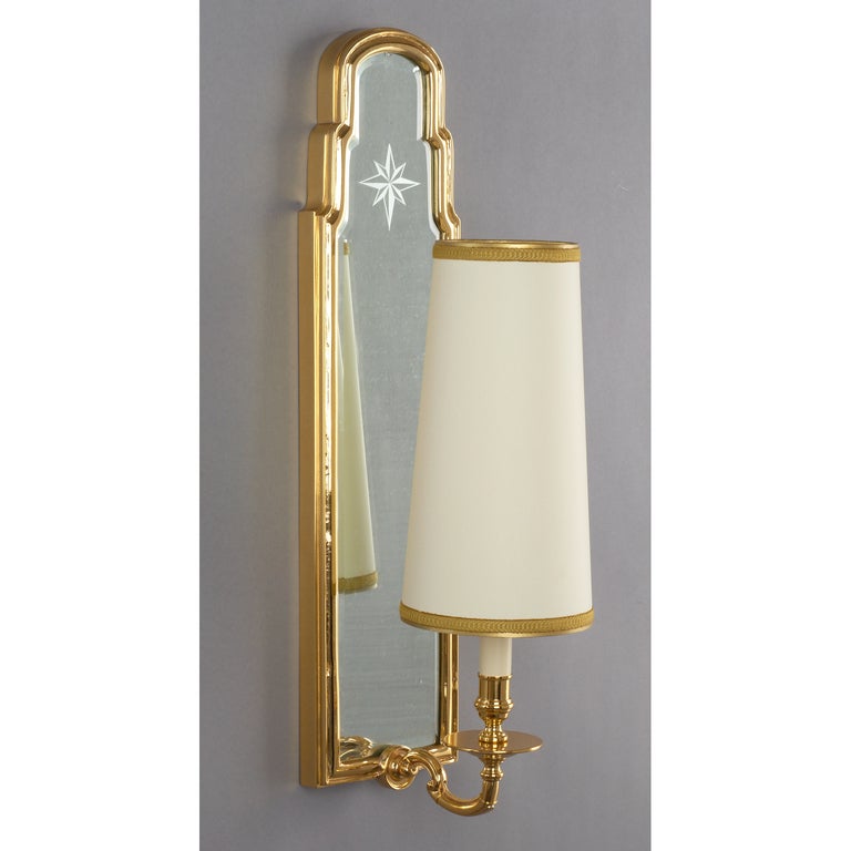 France, 1950s. 
A handsome pair of tall neoclassical mirror back sconces with engraved star motif, cast bronze, engraved mirror.
24 H x 6 W x 9 Proj.
Rewired for use in the U.S.