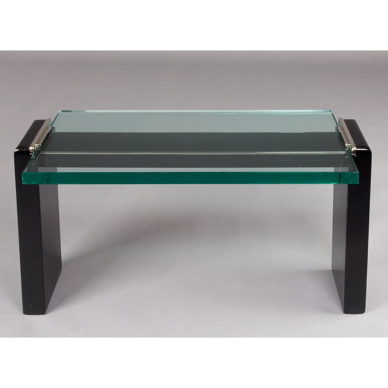 Jacques Adnet (1900-1984), att. to

Modernist coffee table, ebonized wood with nickeled bronze mounts, thick slab glass.
France, 1950's