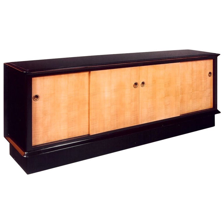 Jacques Adnet (1900-1984).

A stunning large cabinet in sycamore, with ebonized frame and inset black opaline glass top. Four sliding doors with bronze pulls. Interior with two drawers and shelves.
France, 1950s.

Dimension: 98 x 18 x 34.5 H.