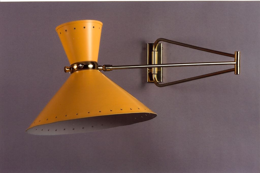 PIERRE GUARICHE  (1926-1995)
Articulated wall light with enameled metal shades with perforated star motif, separately switched up and down light, polished brass mounts.
Rewired for use in the U.S.