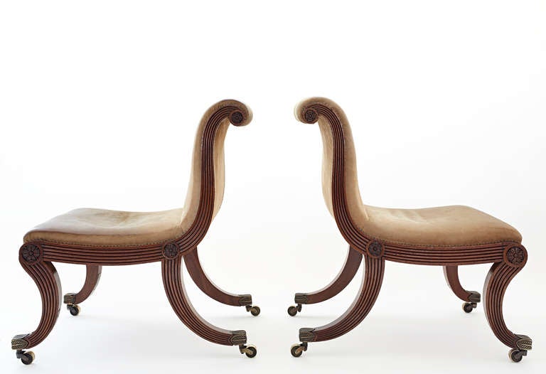 A Pair of George IV carved mahogany chairs upholstered in leather the seat rails stamped 