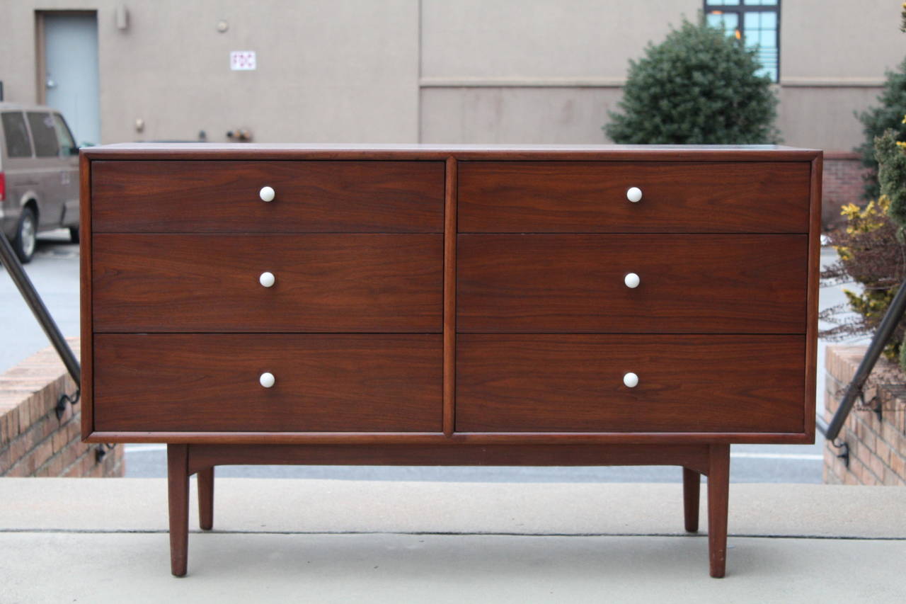 A handsome six-drawer walnut chest or dresser designed by Kipp Stewart for Drexel, 1950s. Chest is accented with beautiful white porcelain pulls. Matching walnut mirror also available (fittings are on back of chest, can be removed if desired).