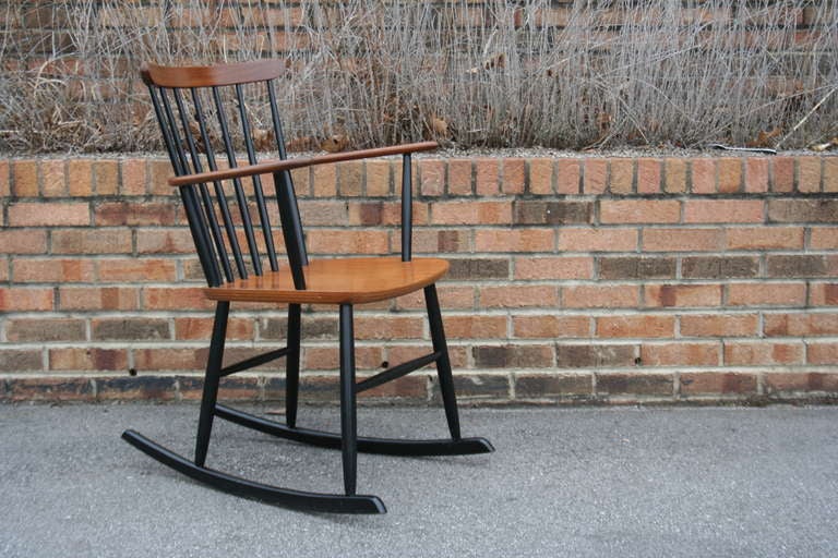 A simple and classic Danish teak rocking chair produced in the mid to late 1960's by Billund Traevarefabrik, Denmark. This chair has a painted wood body with a teak seat, back and armrests. Very sturdy, comfortable and nice looking