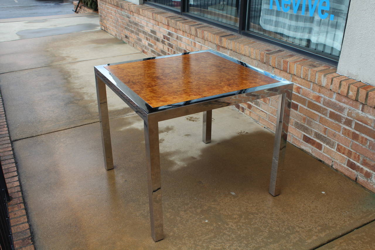 A bright and fun 1970s chrome and burl game table in the manner of Milo Baughman. Polished chrome contrasts well with the olive burl top, sturdy and structurally sound.