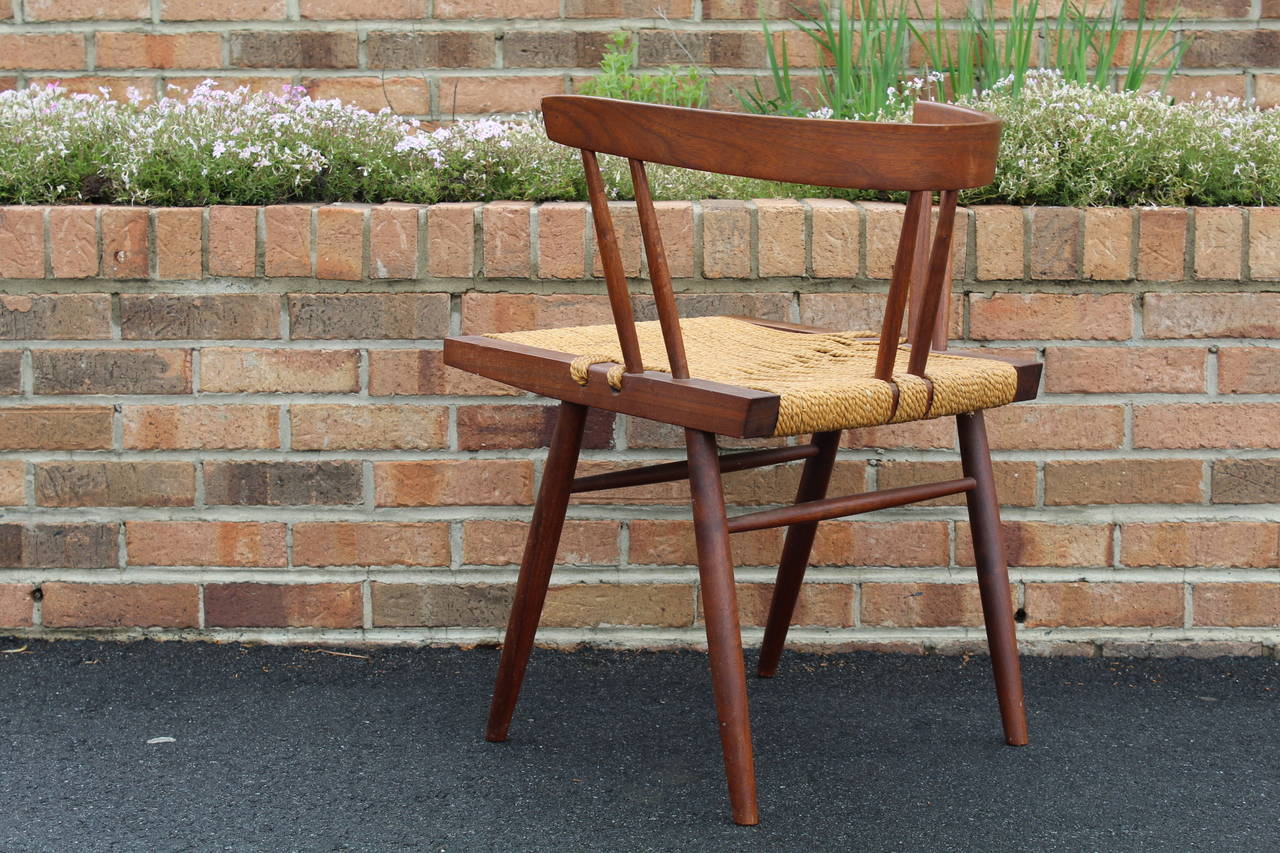 Beautiful grass-seated chair in black walnut by George Nakashima, Nakashima Studios, circa 1960s. A wonderful example of this iconic design.