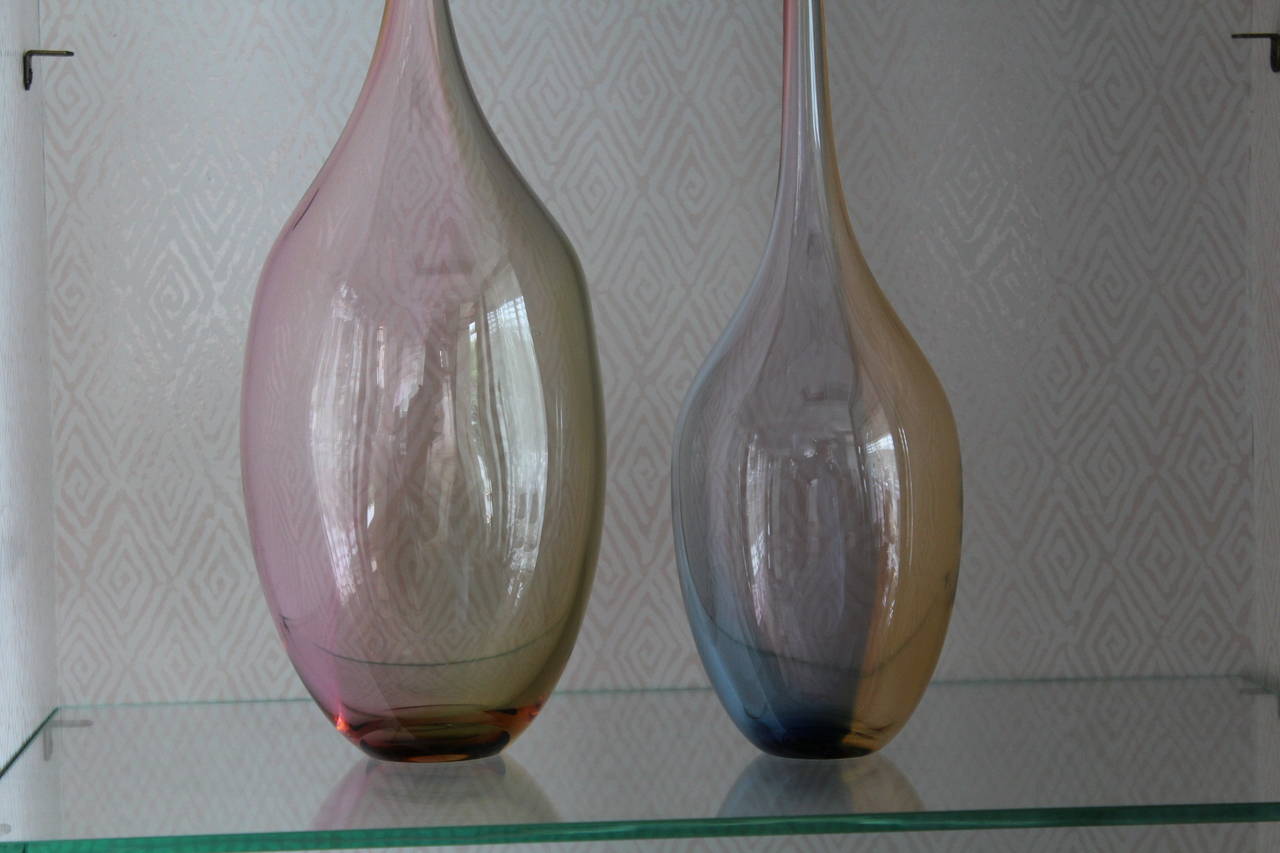 A great pair of bottles or vases designed by Kjell Engman for Kosta Boda, the soft colors and gentle curves of these pieces really make them Stand out on a table or shelf. Notice the different colors throughout the vases as they are rearranged. Each