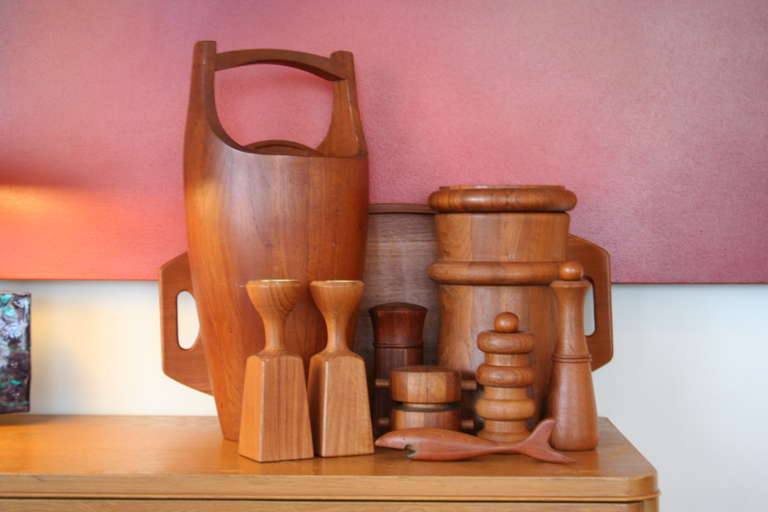 A fine collection of four Dansk peppermills, two ice buckets, a teak serving tray and a pair of candlesticks designed by Jens Quistgaard for Dansk. Shark bottle opener not Quistgaard, but a nice teak piece nonetheless.