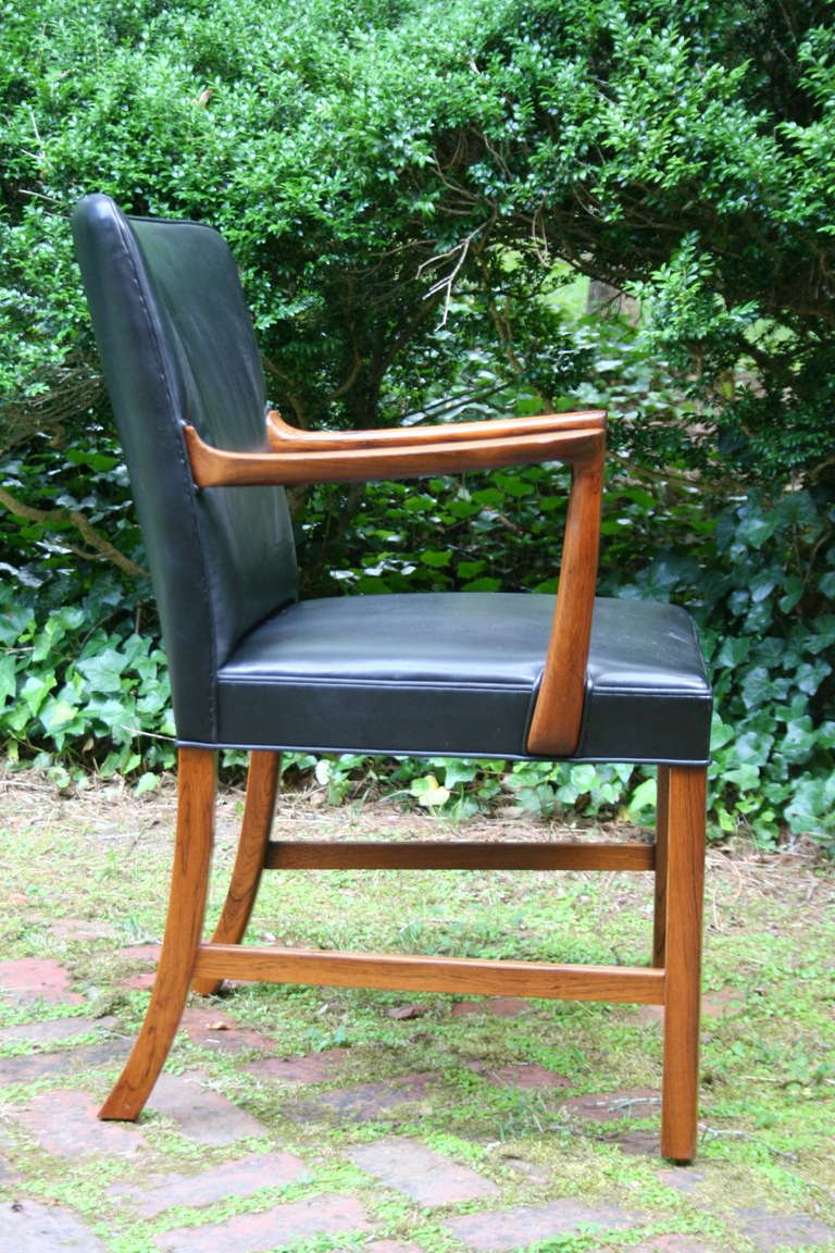 A stunning and classic pair of rosewood and black leather armchairs designed by Ole Wanscher and produced by cabinetmaker A.J. Iversen, Denmark c. 1960.  From the beautiful sculpted rosewood and leather, to the fine craftsmanship throughout, you'd