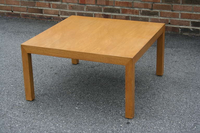 A simple, bleached walnut square cocktail/coffee table designed by Edward Wormley for Dunbar Furniture. This is an early (1940's) parsons-style design by Wormley, Very sturdy and well made, retailed by Mastercraft in Chicago.