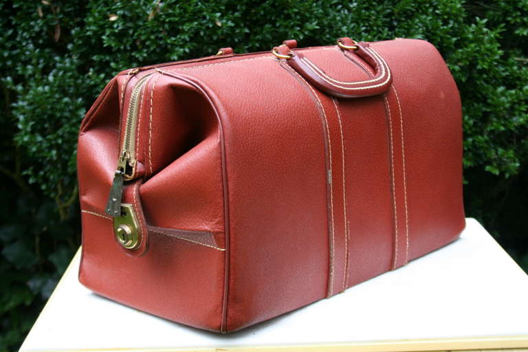 A wonderful pair of vintage red or maroon leather and brass luggage bags. Nice stitching throughout with light patina to brass zippers and locks. Leather is firm showing very little use.
