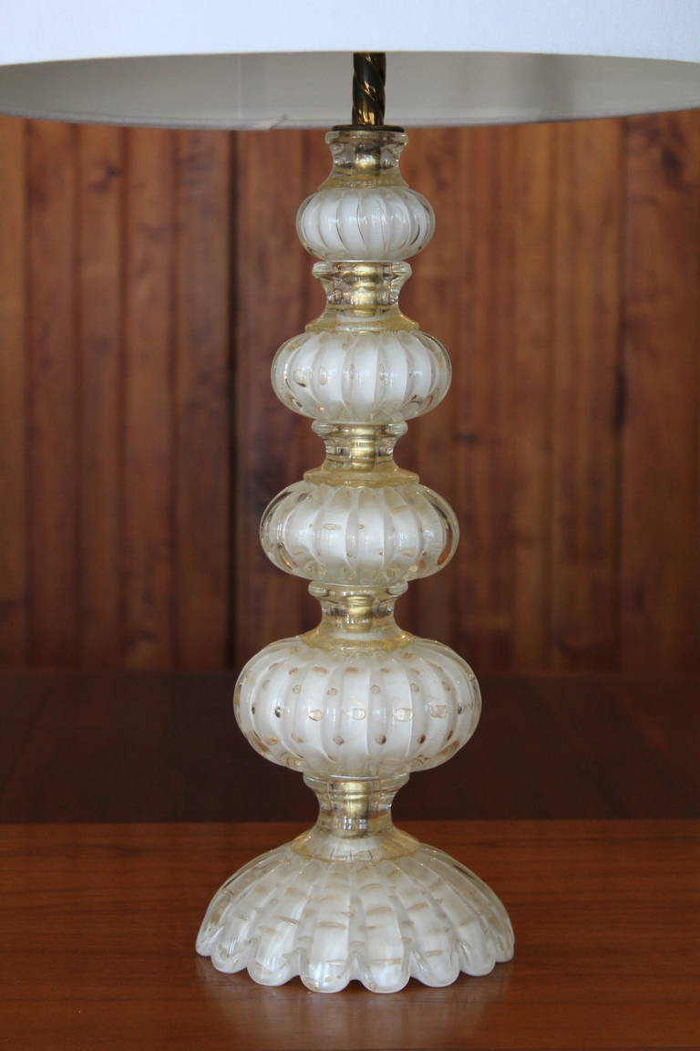 A beautiful scalloped base table lamp by Seguso, c. 1960. Gold leaf and controlled bubbles throughout. Entire lamp is one piece of glass. Subtle colors, a very nice and well finished lamp. 
*Height to socket - 20.25