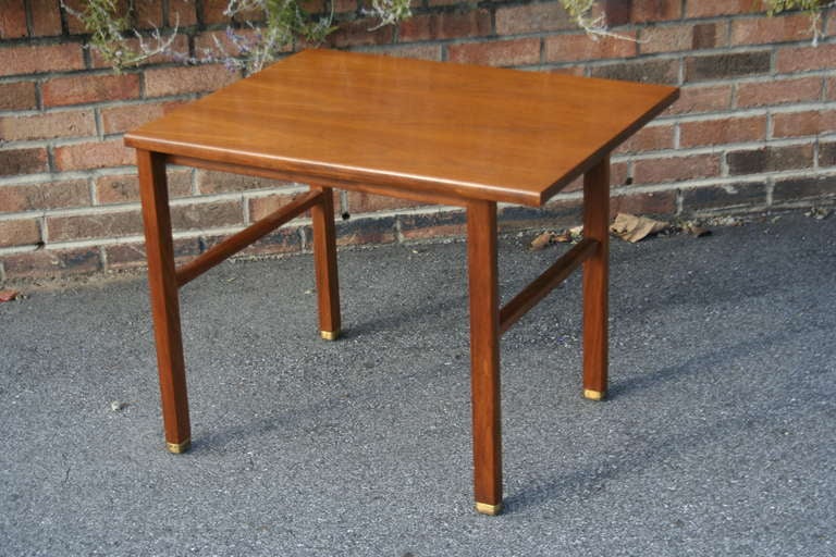 A large walnut cantilever side/end/occasional table designed by Edward Wormley for Dunbar, 1950's. Solid walnut legs, brass capped feet and a book-matched walnut top show the top quality craftsmanship that Wormley and Dunbar were famous for.