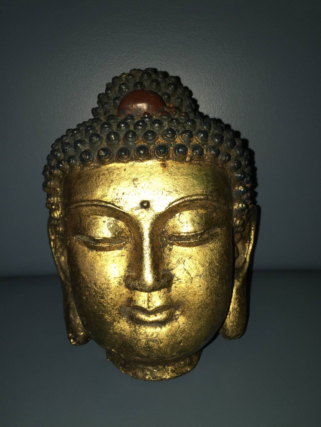 Terrific Mid-Century gold gilded Buddha head sculpture. Comprised of an iron material in the form of a Buddha with gold gilded paint.