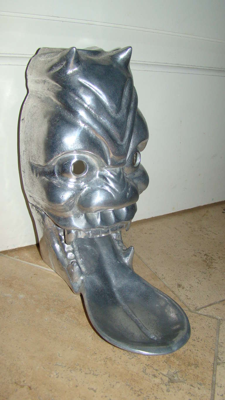 Terrific Wall Hanging Mask Sculpture by Arthur Court, 1977. This interesting piece is comprised of cast aluminum and depicts a devilish face with tongue sticking out. Marked Arthur Court 1977. Designed to hang on the wall.