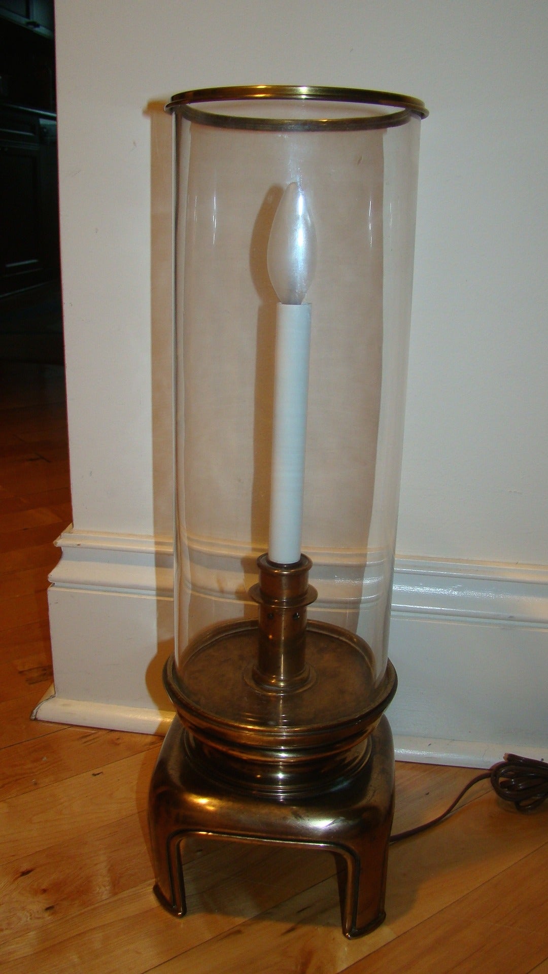 Terrific sculptural brass and glass hurricane style table lamp by either Stiffel or Chapman. The lamp is comprised of a heavy sculptural brass base with removable glass tube shade. Truly a beautiful design in person.