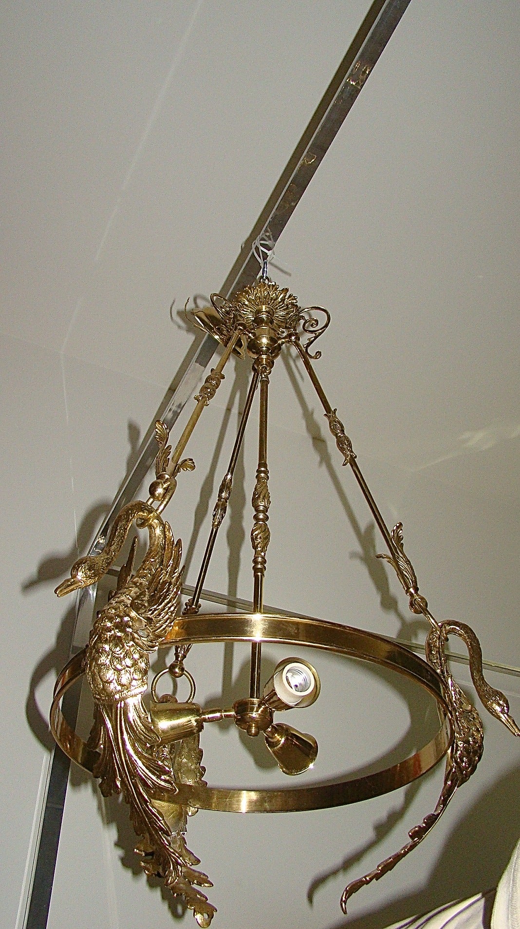 Glamorous Italian brass Empire style sculptural swan chandelier. This unique design is comprised of solid brass and depicts three swans with long necks each of which connects to a ring to support the fixture. Signed with metal made in Italy tag.