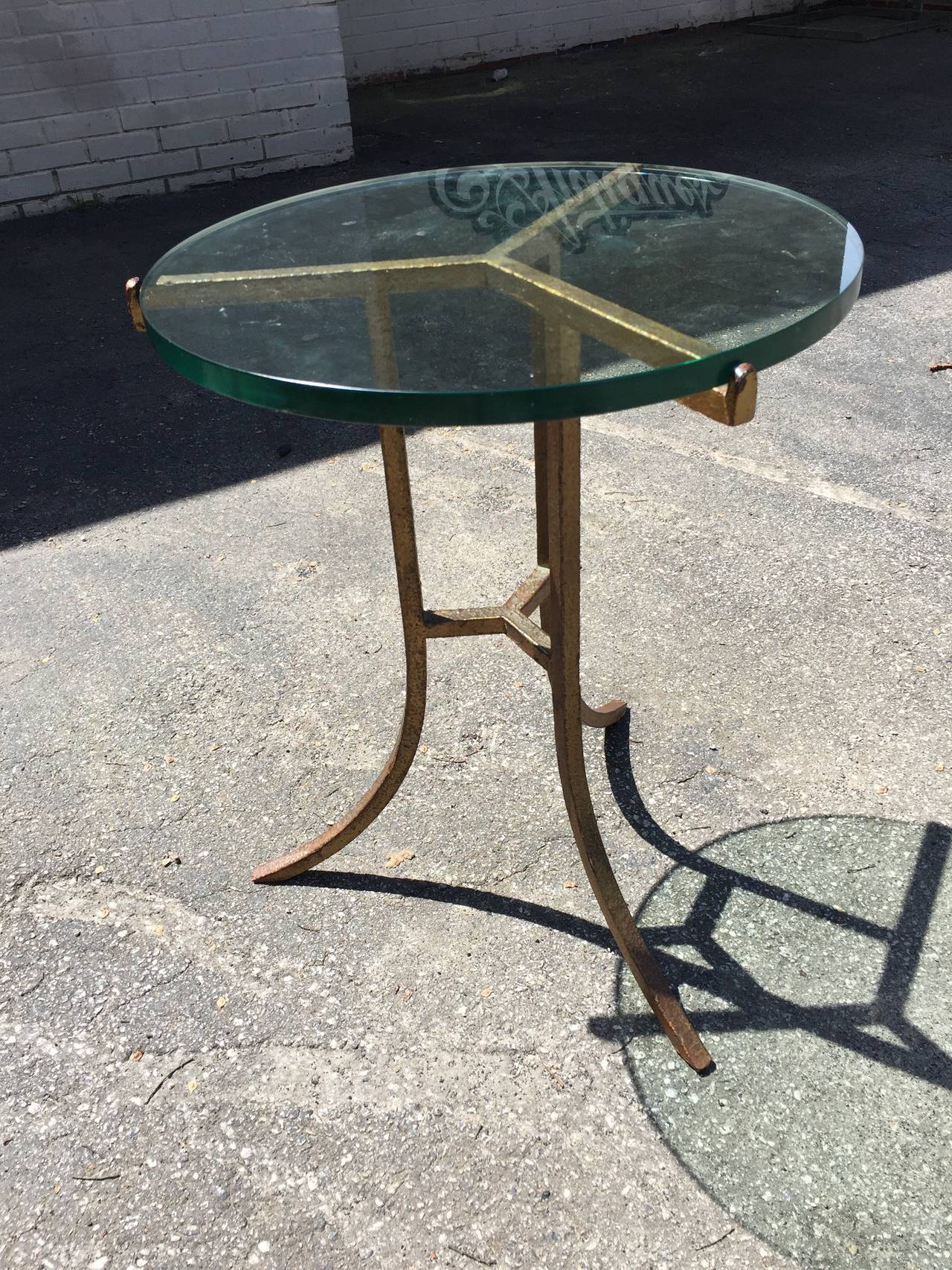 Exceptional Mid-Century sculptural glass top occasional table. This interesting piece is comprised of a heavy iron base with gold rough surface painted finish and thick 1