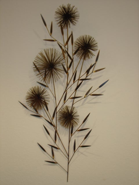 Tall slender metal wall sculpture created/signed C Jere. The sculpture is brass with sea urchin sputnik rods and leaves.