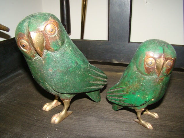 Terrific pair of Owl Sculptures by famed Mexican Artist Sergio Bustamante. This interesting pair are each comprised of sculputed wood with hand hammered brass faces and solid brass feet. Signed and number 55/100. Smaller owl measures 4.5