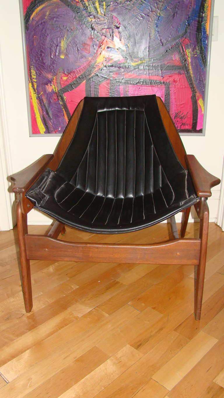 Terrific Mid Century Sling chair designed by Jerry Johnson. Extremely comfortable design featuring original black sling seat with sculptural walnut wood frame much in the style of kagan or pearsall.