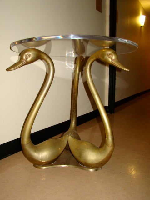 Exceptional Brass & Lucite Swan Table. This beautiful design is comprised of 3 Sculptural Brass Swans with thick Lucite Top. Can be used with a larger glass top for more seating.