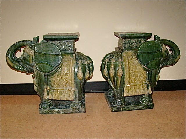 Terrific pair of vintage Glazed Terracotta Elephant Garden Stools. This beautiful pair are each comprised of hand glazed & painted terracotta pottery and are extremely heavy.  They depict whimsical elephants with the trunk in the upright position.