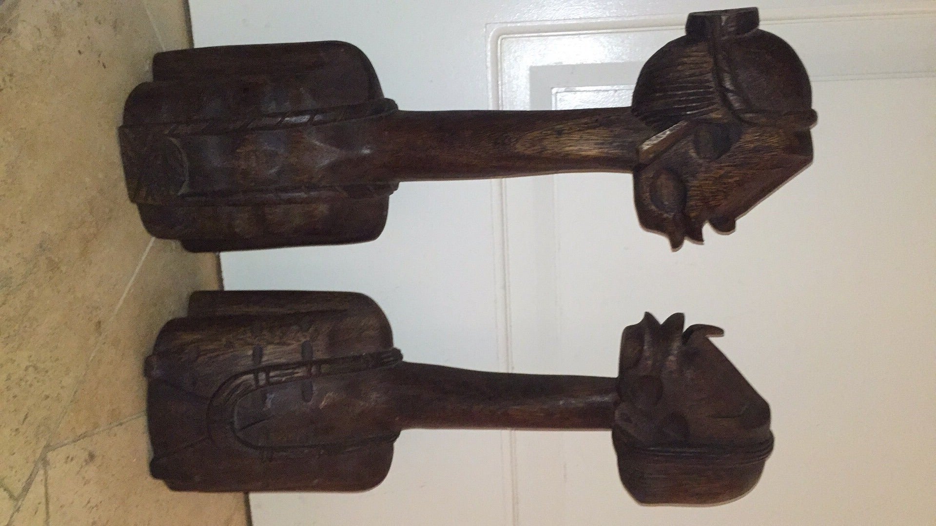 Terrific pair of vintage whimsical hand-carved wood sculptures. This interesting pair depict a long neck tribal male and female possibly African, Jamaican or Haitian. Truly a unique pair of sculptures in person.