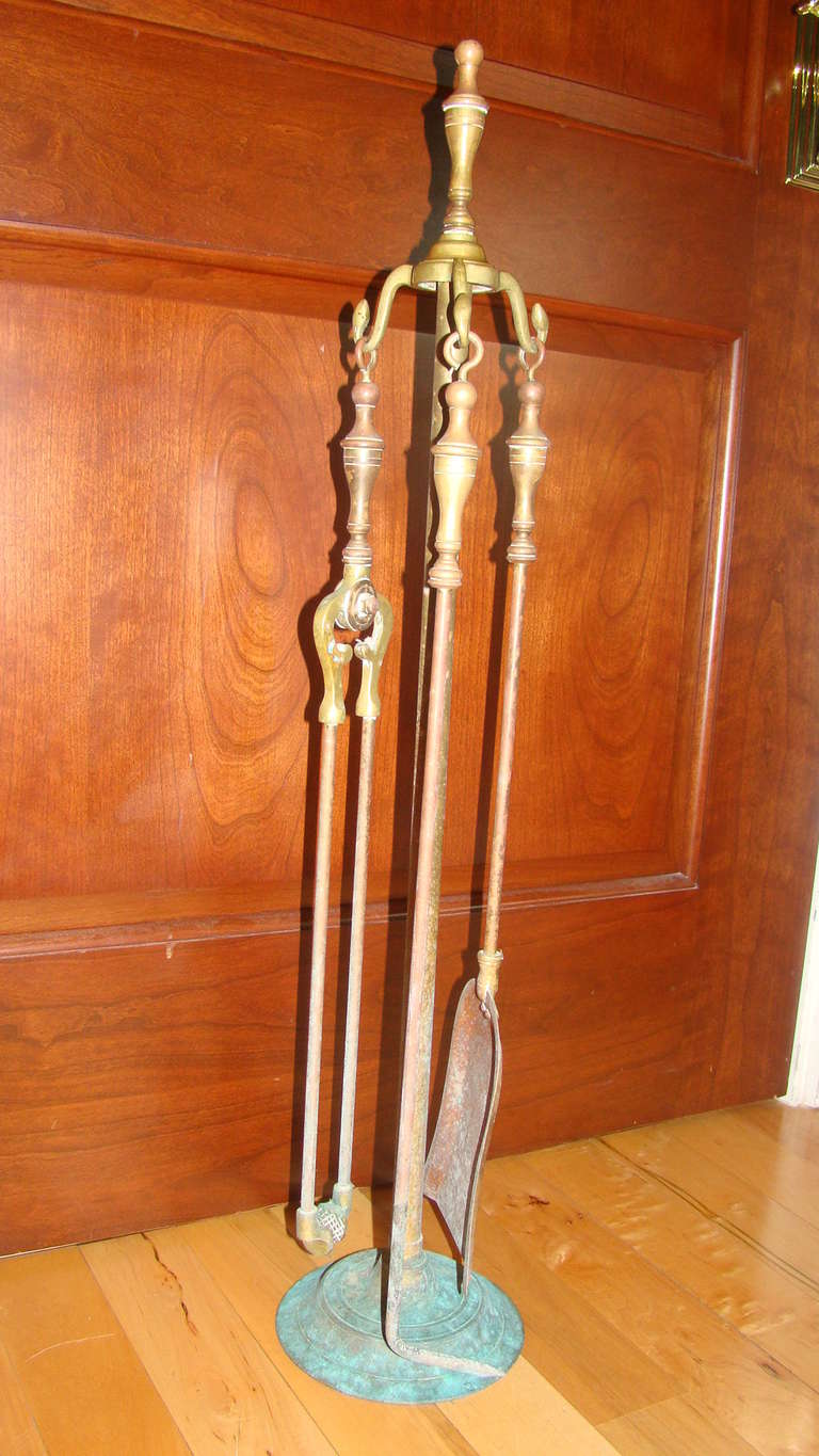 Great set of antique sculptural brass fire tools. Three tools with finely detailed handles hang on the base. Rich warm patina throughout the brass.
