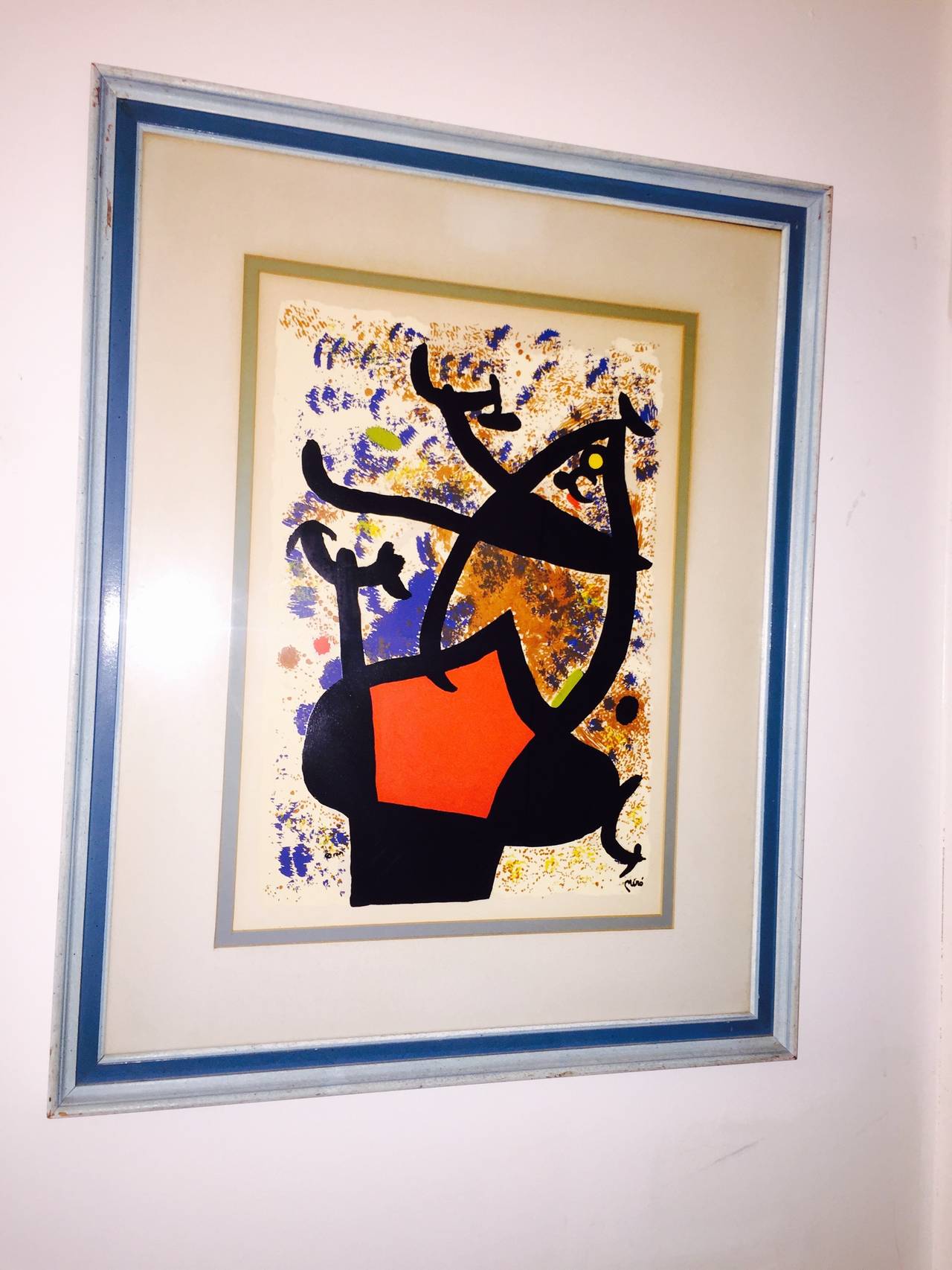 Beautiful vintage large color lithograph by Joan Miró. Vibrant colors in the Classic Miro form. Signed in the plate. Framed in a vintage blue wood frame behind glass.