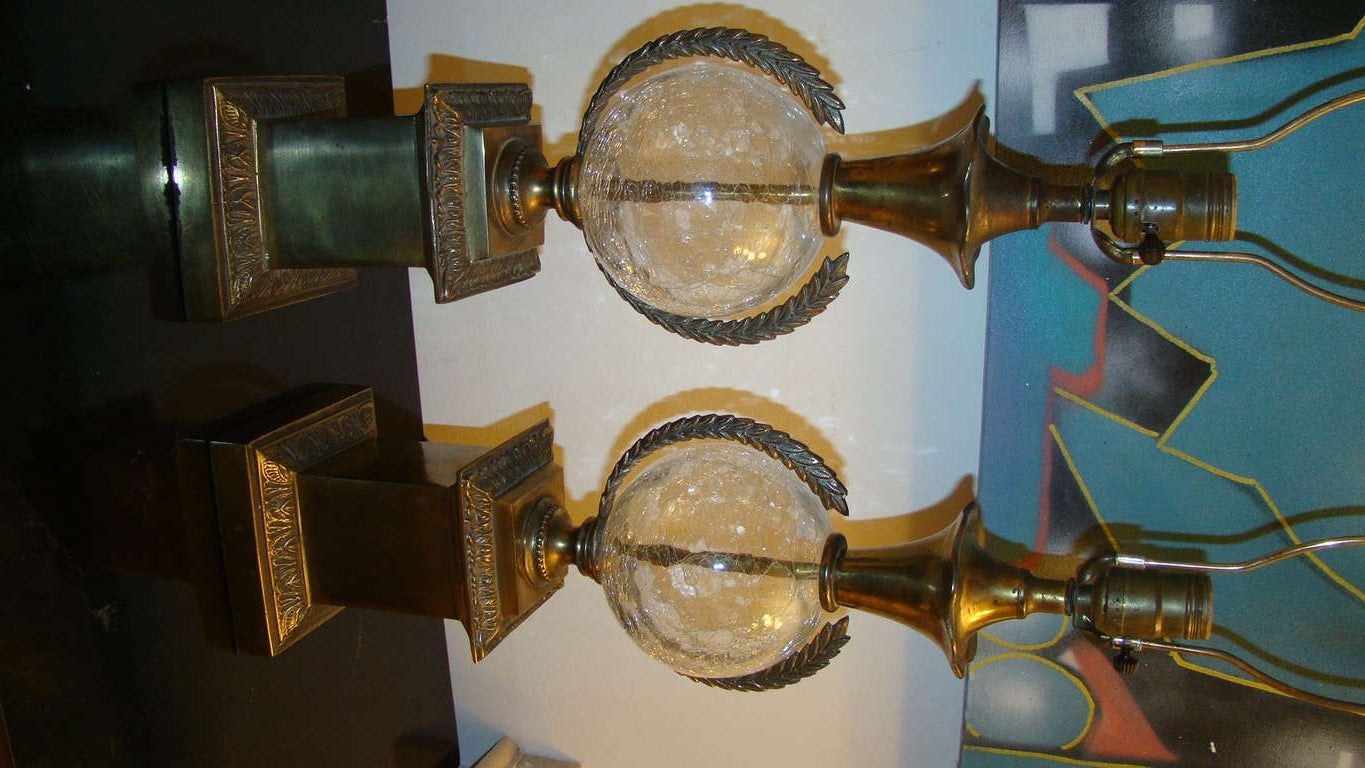 Terrific pair of table lamps by Paul Hanson. Each lamp is comprised of a clear crackle glass center with sculptural brass wreath and bases. Truly a beautiful pair in person!