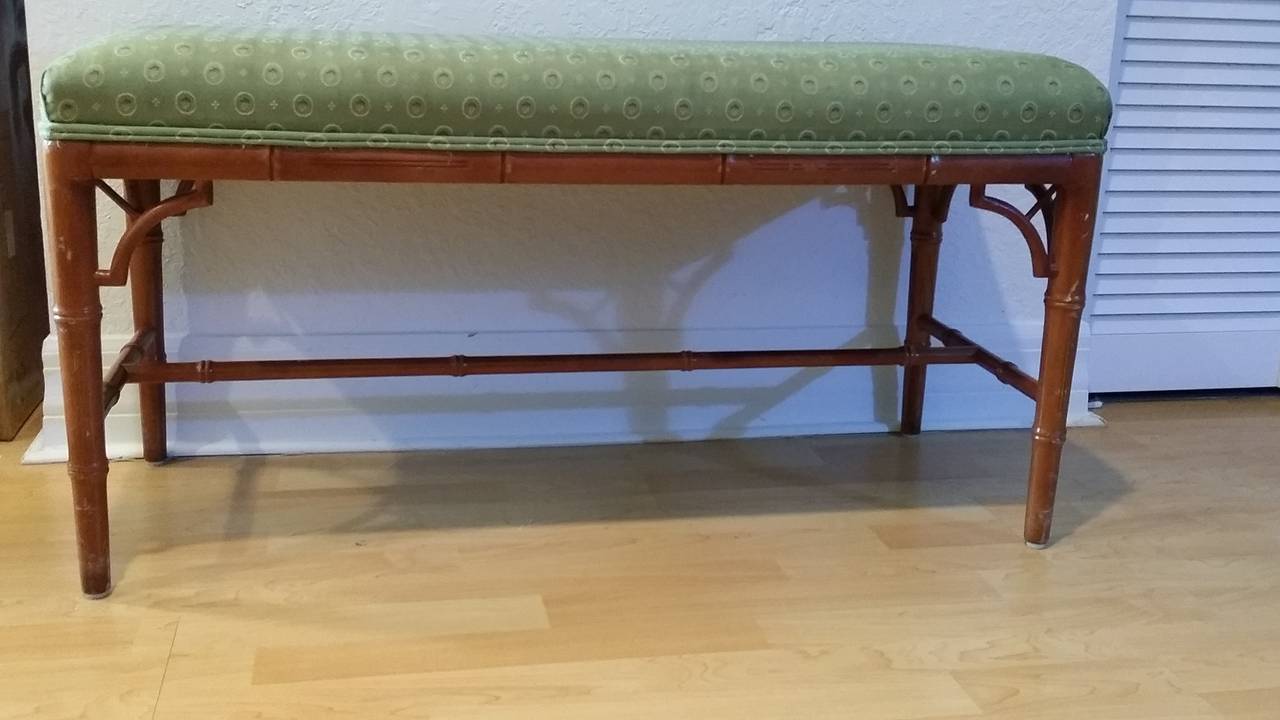 A beautiful and practical piece of vintage furniture. Wood faux bamboo bench very good condition. Light green designer upholstery, however can easily be reupholstered to match your interior. Although, there is only one shown we do have a pair of