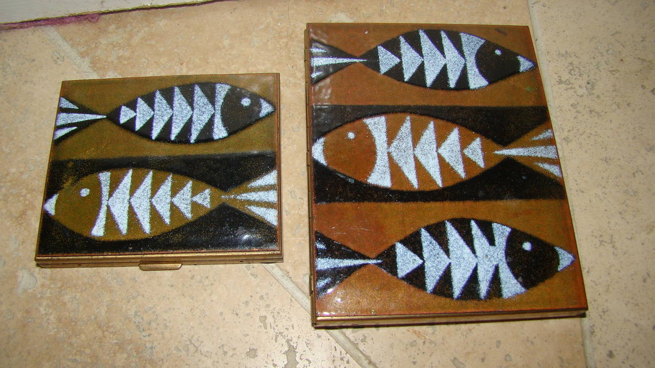 Exceptional Mid-Century or Art Deco compact and cigarette case. This beautiful set has a baked enamel front with modern fish design and brass casing. The smaller one has a mirror and makeup section and the larger is for cigarettes. Truly a beautiful