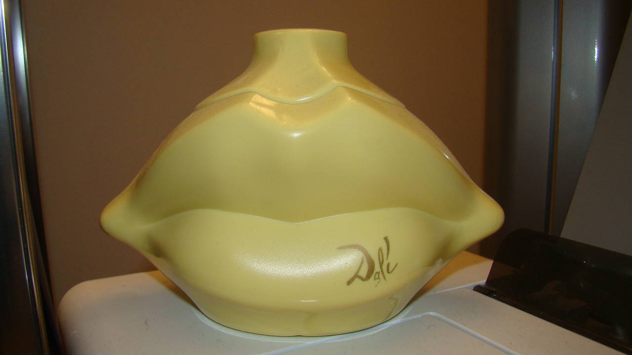 Terrific vintage Salvador Dali sculptural lips powder box. Comprised of a plastic double sided lips form with unused powder poof inside. Signed Dali made in Paris.