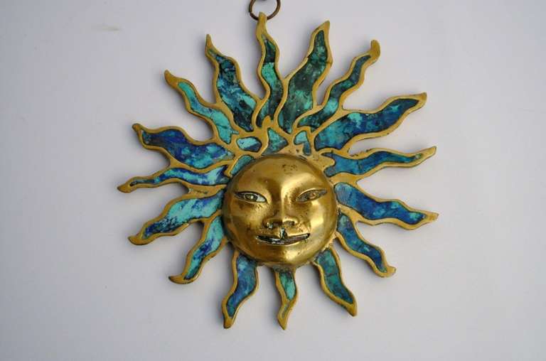Exceptional sun face wall hanging sculpture by Pepe Mendoza, signed. This beautiful piece is comprised of solid heavy brass or bronze with green sodalite inlay. It hangs from the original brass chain with matching hanger. With chain it measures 30