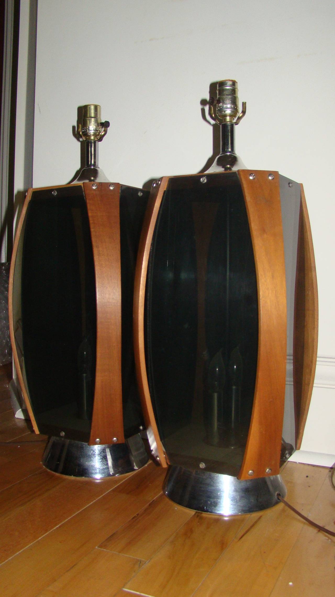 Terrific pair of Danish modern table lamps. Each is comprised of a sculptural teak wood with smoked acrylic sides and chrome bases. Truly a unique design in person.