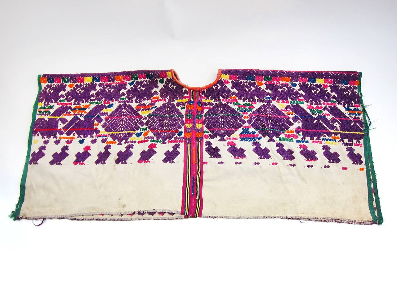 Following a tradition of over 1,000 years, the Maya people of today still employ the backstrap loom to create the traditional garment - the huipil. Woven cotton forms the base for a brilliant show of embroidered Mayan motifs, animal figures and