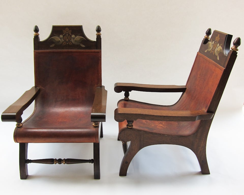 A very nice pair of armchairs made from tropical perota wood with hand painted head supports, gold leaf detailing and leather seats by Alejandro Rangel Hidalgo (whose style was known as “Rangelino”.) 
Rangel Hidalgo (1923-2000) was an artist,