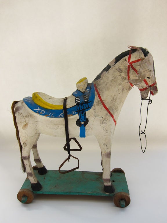 In the town of Celaya, Guanajuato, painted papier-mache toys have been a tradition for over a century. This type of horse came in all sizes, and mounted on a base with wheels so that children could ride.  This particular horse shows the strain from