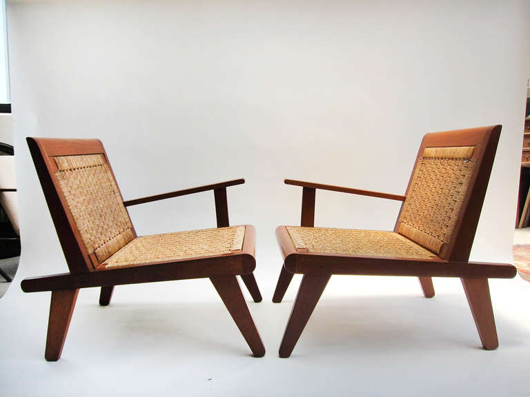 These mid-century lounge chairs boast very strong handsome lines, suggestive of Aztec architecture. Adding to their appeal and in warm contrast are the hand woven palm fiber seats and backs. Constructed of solid red cedar, these unusual chairs are