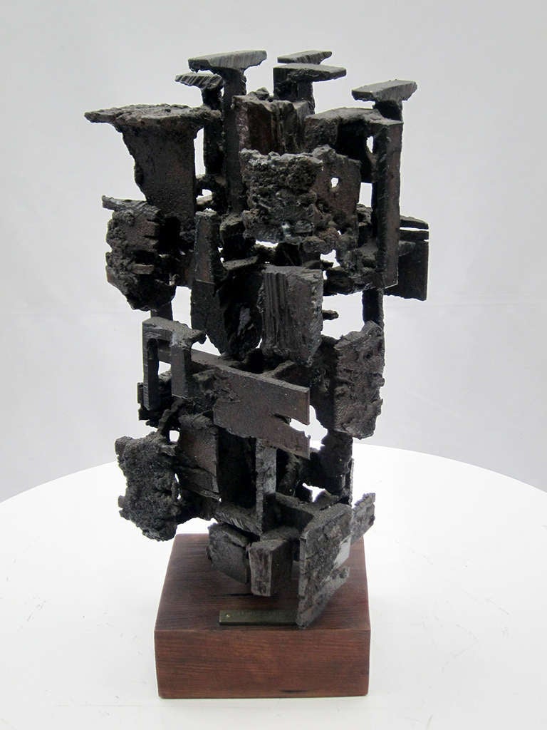 A tower of fused iron fragments creating a compelling composition of form and space. The sculpture pivots on its base giving a new dimension with each turn. Jorge Santo Kaminski was born in Mexico of Polish/Hungarian parents.  A prolific sculptor