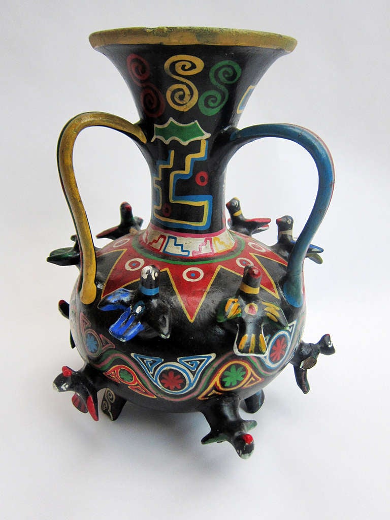 A whimsical polychromed vessel of black clay incorporating pre-hispanic motifs. This freehand painted vessel with 12 applied birds is from Acatlán, a ceramic center of importance which produced and produces distinct types of ceramic, one of which is