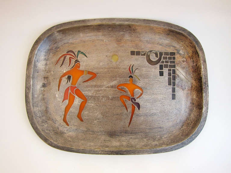 This silver plated tray is beautifully crafted with the depiction of 2 aztec warrior-players at the pre-Columbian game of tlachtli , a sacred ball game. The inlay is done in pluma azteca, a complex art using feathers (and which can be appreciated by
