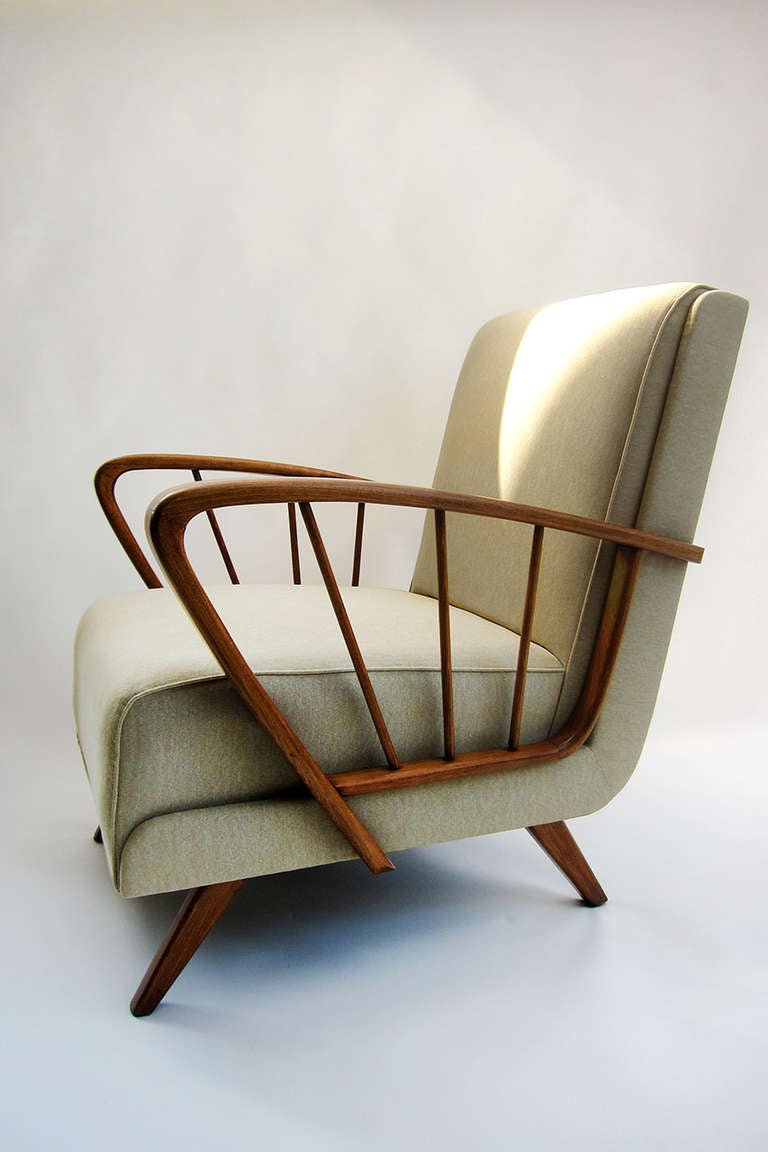 Done is ashwood, the gracious lines of bentwood with contrasting rectilinear lines give this chair a wonderfully bold presence in the atomic tradition. Yet the luster of the wood and the pale fabric soften the form completely. 
Inner-spring