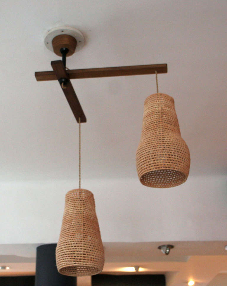Made by contemporary Mexican designers Perla Valtierra and Ricardo Rodriguez, La Carpinteria. Two arms made of solid walnut and hand woven palm leaf shade. Each arm has independent movement.