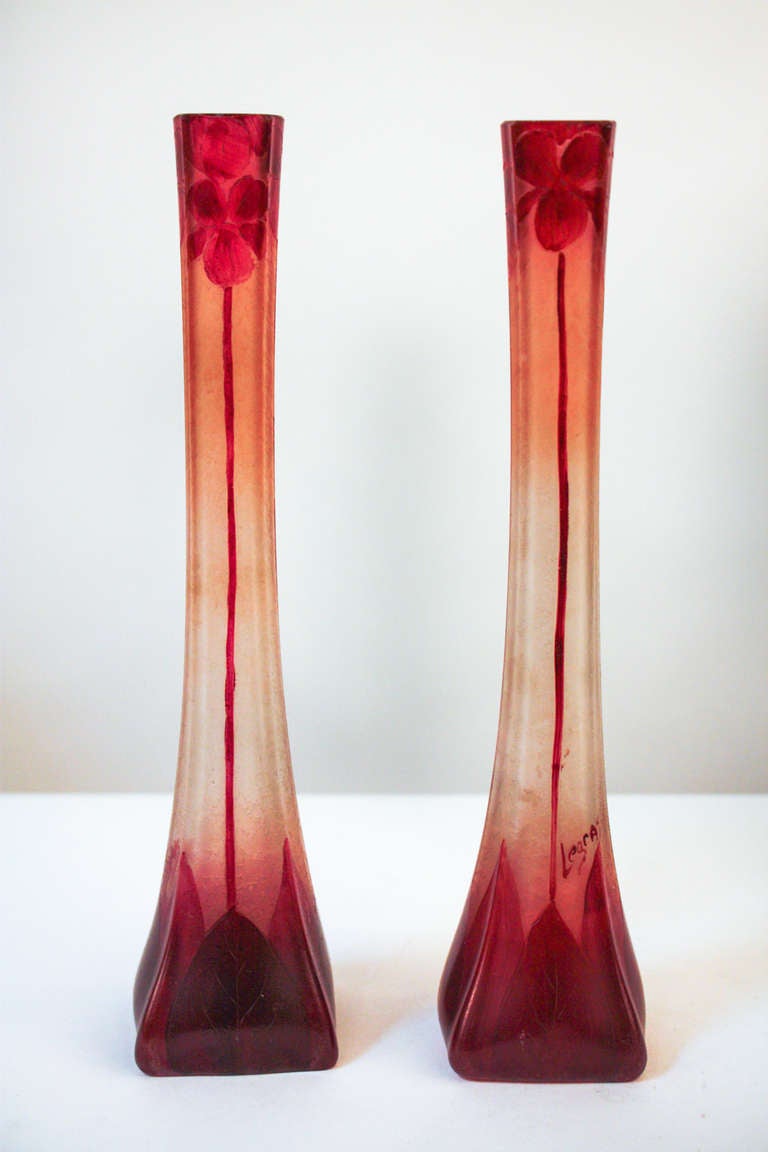 A stunning pair of vases. Made from acid cut glass, the vases exude a beautifully vibrant purple/red color. One of the pair is signed 