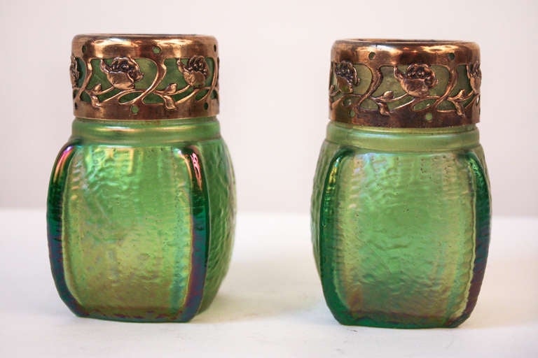 A beautiful pair bohemian art glass mini vases. Made by the world renowned Loetz glassmakers in the Czech Republic, this stunning pair of vases features a translucent yet vibrant green glass, and polished nickel overlay top rim. This is a great