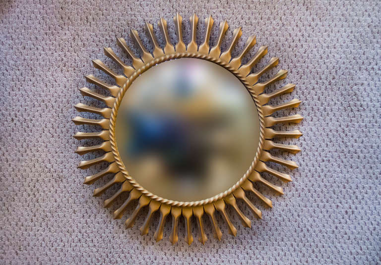 A beautiful mid-century mirror from France. An elegant sunbust design beautifully combines with this mirror's convex surface, making for an excellent art deco piece.

This mirror bears the maker's mark, 