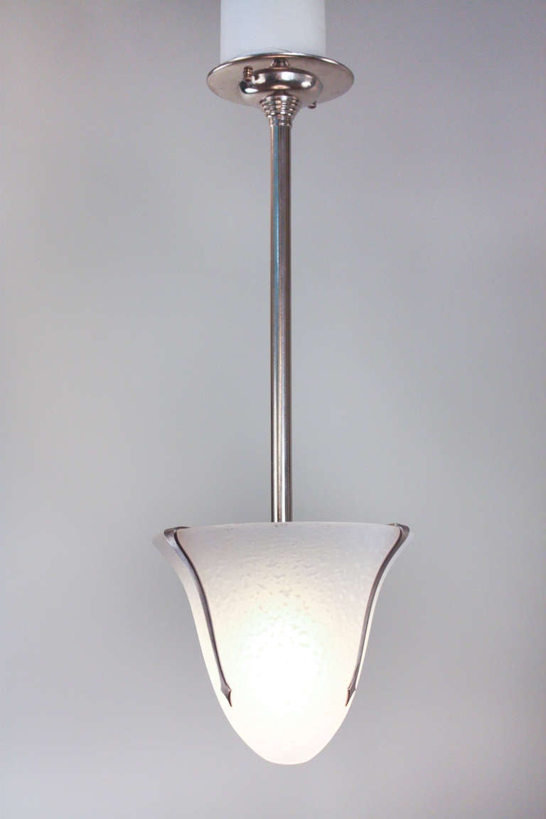 Un magnifique lustre à une seule lumière qui combine élégamment le design moderne et Art Déco. Fabriqué en verre soufflé à la main, ce luminaire est complété par de spectaculaires ferrures en nickel. 

Si l'espace le nécessite, la tringle peut